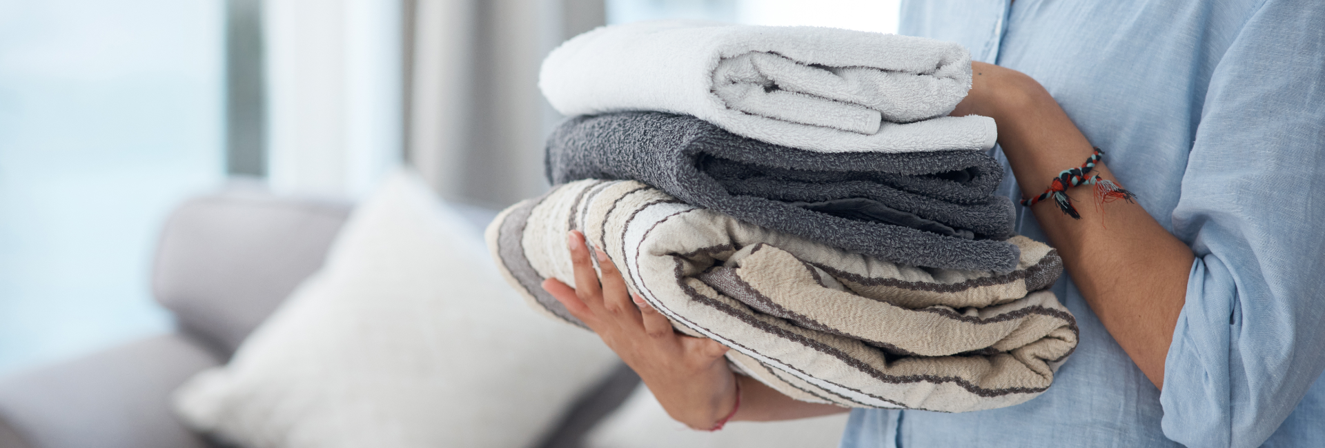 Hands Holding Stack Of Towels 1920X650
